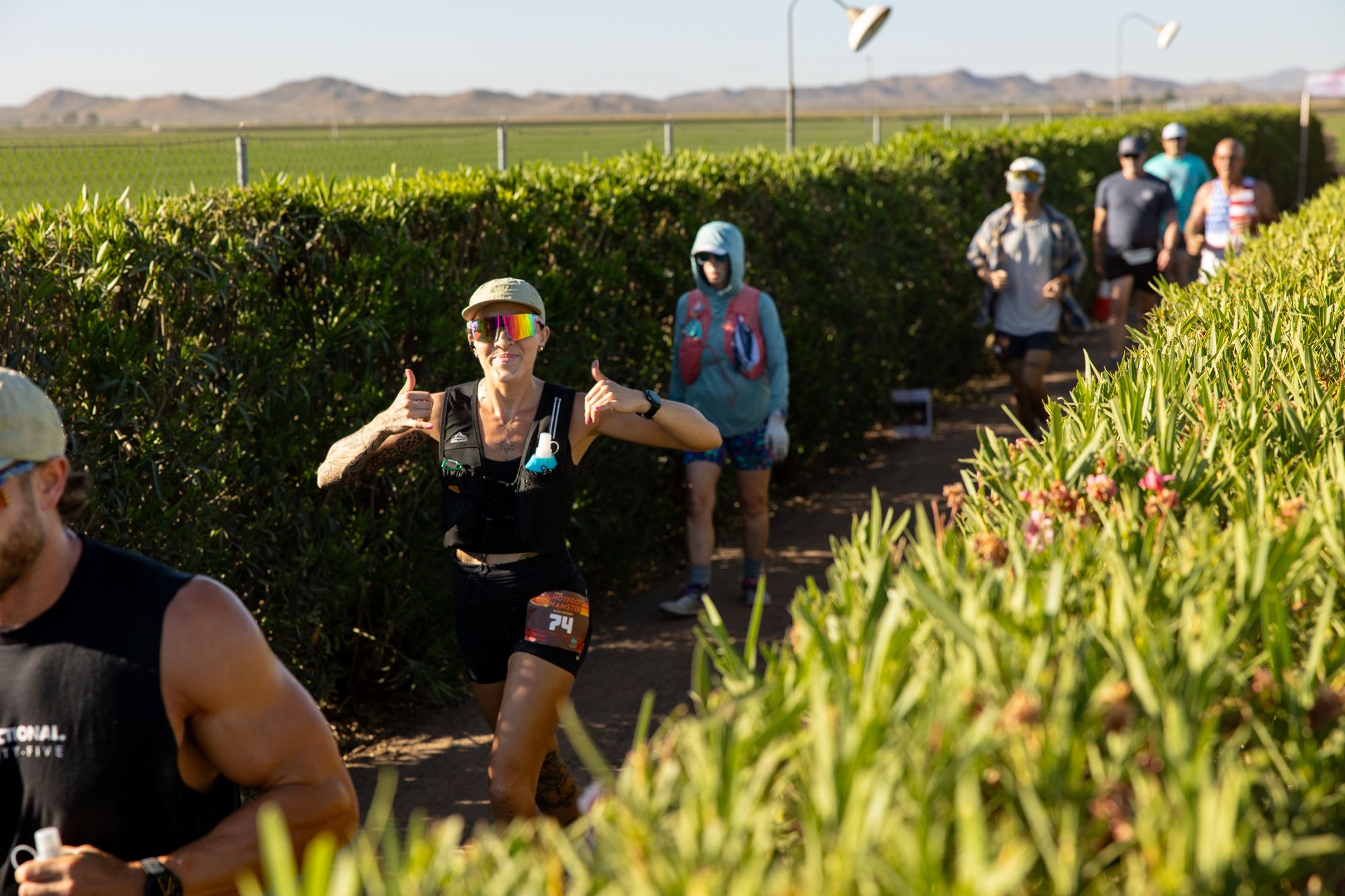Runners coming through the hedges
